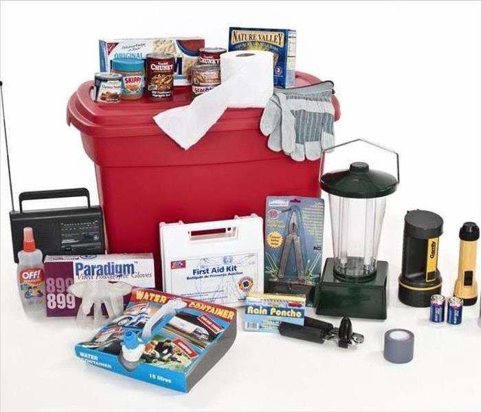 A red emergency tote with a medical kit and other assorted emergency items.